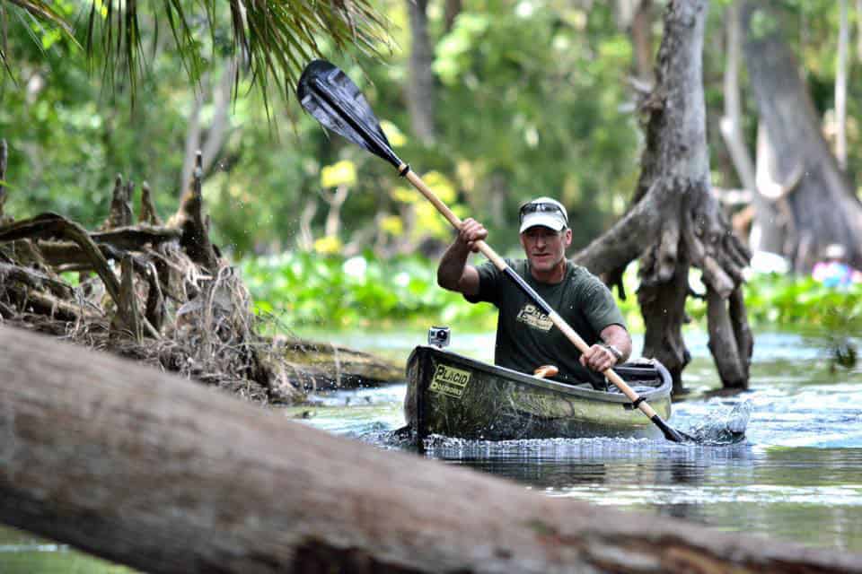 man paddling Placid Boatworks lightweight pack canoe through swamp